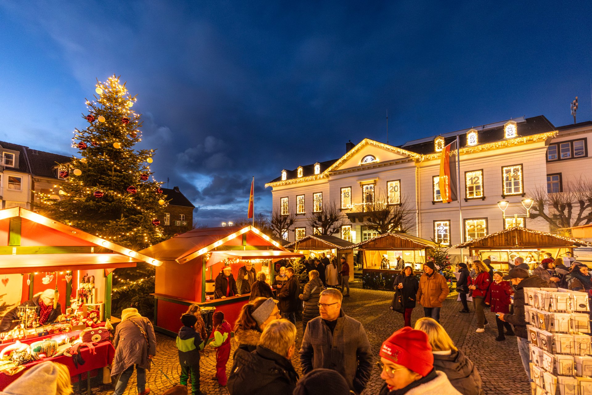 Das Foto zeigt den Adventsmarkt mit Hüttendorf auf dem Kirchplatz und Mittelaltermarkt rund um St. Peter.