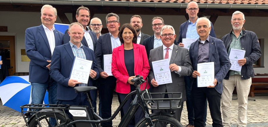 Das Foto zeigt Ministerin Schmitt mit den Vertretern der beteiligten Kommunen.