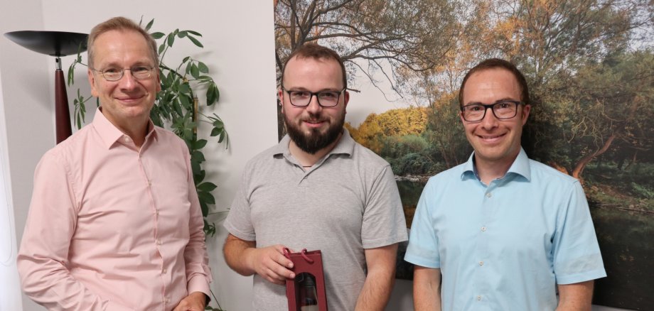Das Foto zeigt Bürgermeister Andreas Geron und Bauamtsleiter Marco Knieper, die Bernhard Wördehoff zur bestandenen Prüfung gratulieren.