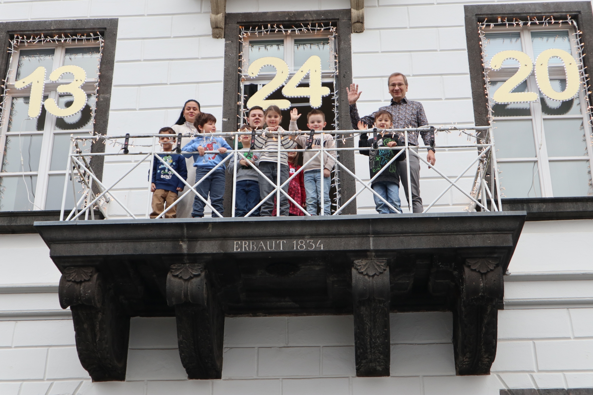 Das Foto zeigt Kinder der Kita Spatzennest gemeinsam mit Bürgermeister Andreas Geron auf dem Rathausbalkon.