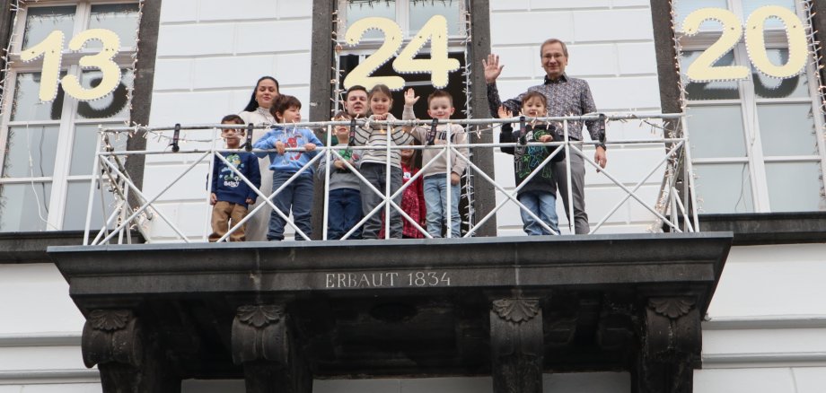 Das Foto zeigt Kinder der Kita Spatzennest gemeinsam mit Bürgermeister Andreas Geron auf dem Rathausbalkon.