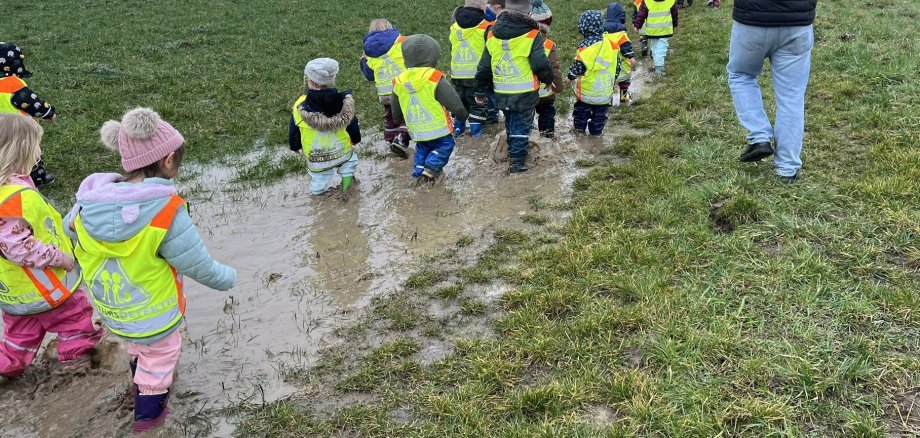 Koisdorfer Wilde Hummeln auf tierischer Entdeckungstour Das Foto zeigt die Kita-Kinder beim Marsch durch die tiefen Pfützen.