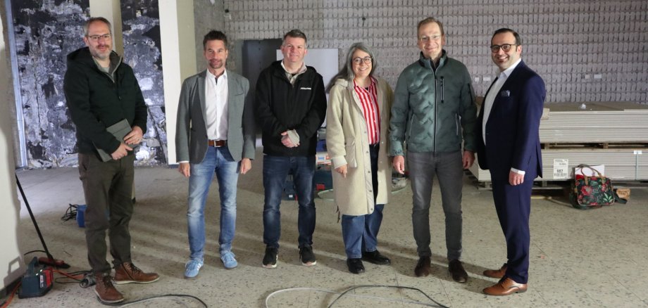 Umbauarbeiten für Umzug und Modernisierung der Stadtbibliothek in vollem Gang Das Foto zeigt den Bürgermeister sowie Mitarbeiterinnen und Mitarbeiter der Stadt gemeinsam mit Vertretern der VR Bank auf der Baustelle.