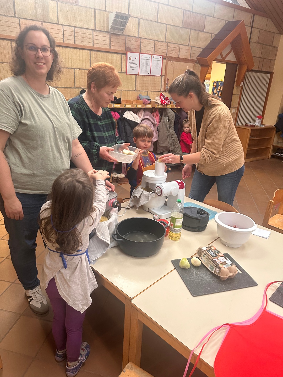 Das Foto zeigt Mütter und Kinder der Kita Storchennest beim Kochen.