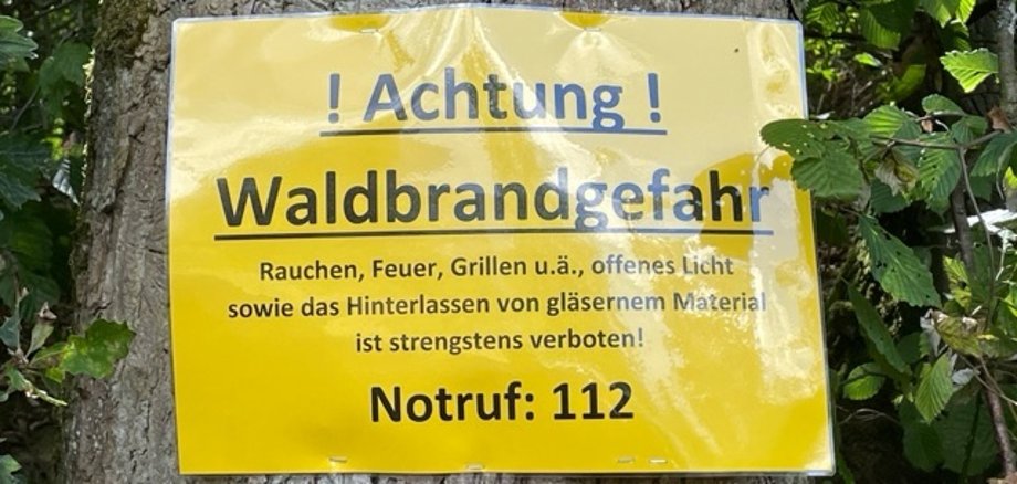 Das Foto zeigt ein Warnschild im Wald