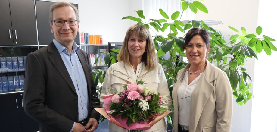 Das Foto zeigt Hedwig Schneider, die von Bürgermeister Andreas Geron und der Leiterin des Fachbereichs Finanzen, Antje Thürmer verabschiedet wird.