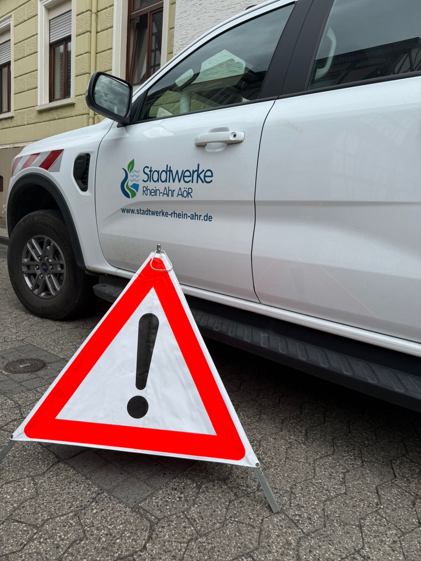Das Foto zeigt ein Auto der Stadtwerke und ein Baustellenschild.