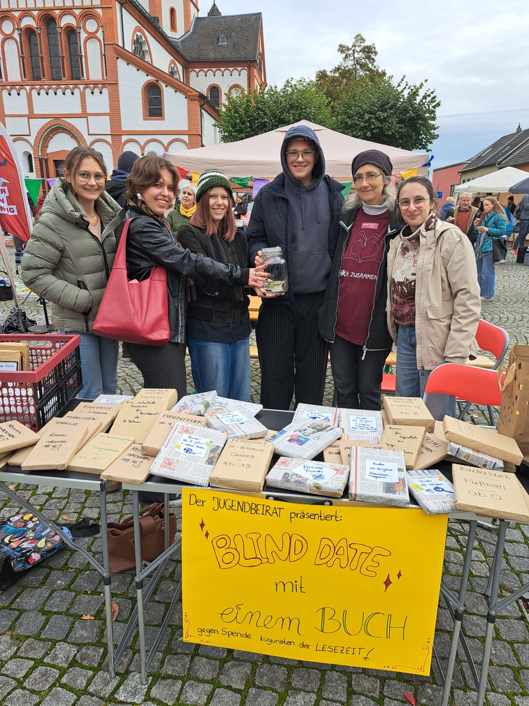 Das Foto zeigt Mitglieder des Jugendbeirats, die Frau Schneider von der Lesezeit eine Spende überreichen.
