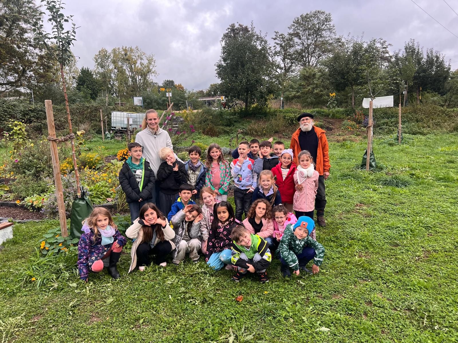 Das Foto zeigt eine Schulklasse mit Ihrer Lehrerin im Gemeinschaftsgarten Sinzig.