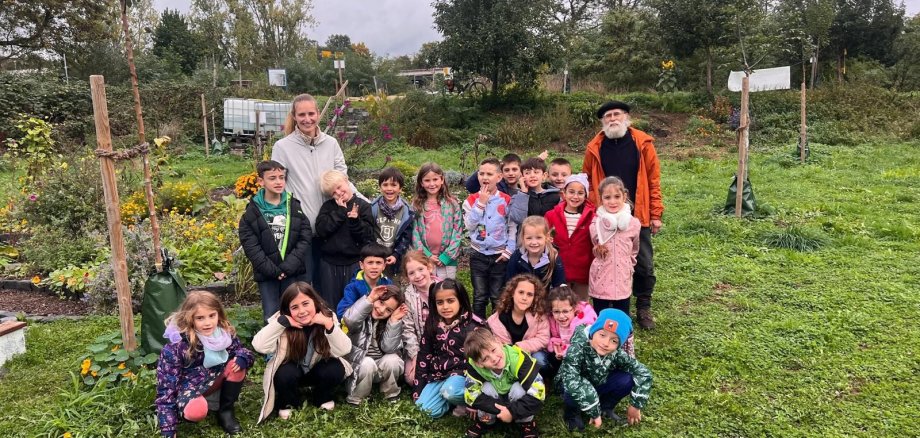 Das Foto zeigt eine Schulklasse mit Ihrer Lehrerin im Gemeinschaftsgarten Sinzig.