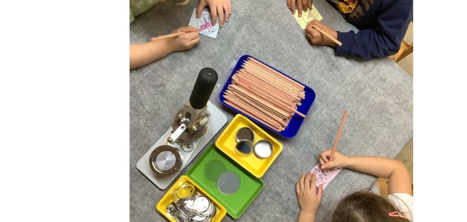Auf dem Foto sieht man drei Kinder beim Basteln.