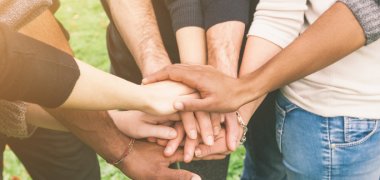 Migranten die Hand reichen Das Bild zeigt, wie sich Menschen die Hand reichen.