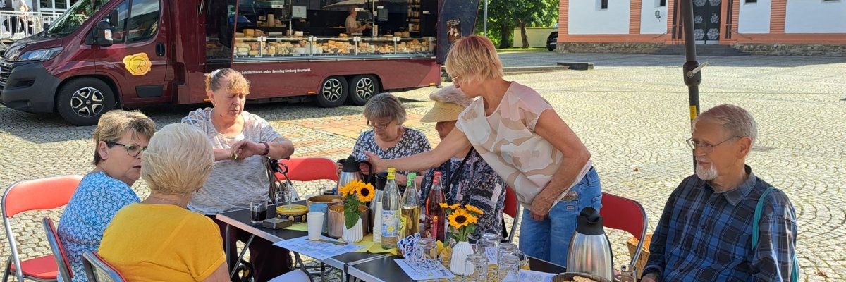 Markt-Klapp-Cafe Das Foto zeigt Gäste des Markt-Klapp-Cafes auf dem Sinziger Kirchplatz.