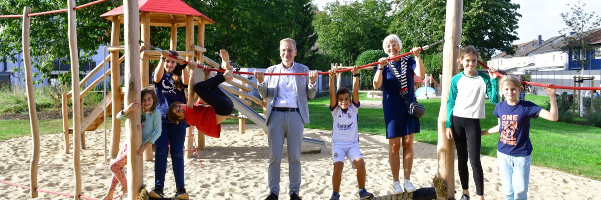 Eröffnung des Spielplatzes "Am Teich" nach Wiederaufbau. Das Foto zeigt Bürgermeister Andreas Geron und die stellvertretende Sinziger Ortsvorsteherin Pia Wasem mit Kindern auf dem wiedereröffneten Spielplatz "Am Teich" in Sinzig.
