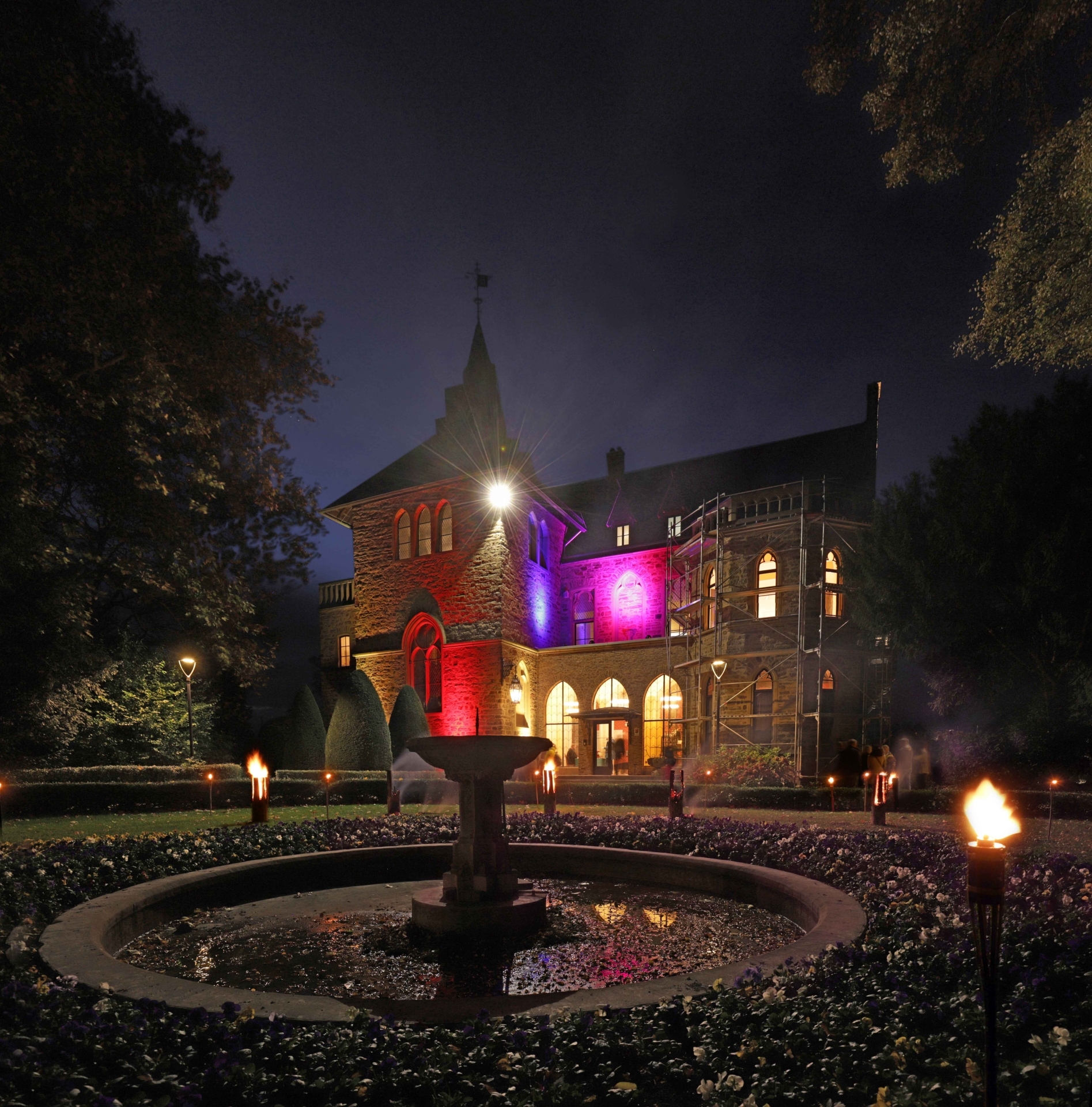 Das Foto zeigt das Sinziger Schloss bunt beleuchtet bei Nacht.